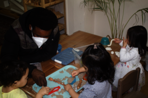 Children playing with a volunteer at The Nest