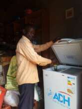 Group member with new solar freezer in his shop