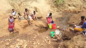 Marita collects water at village's OLD source.