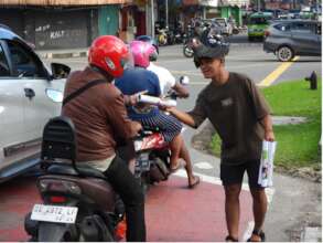 Handing out parrot posters in the Ambon traffic