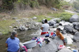 Women with children washing clothes in the river