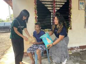 Giving food packet to visually impaired elderly