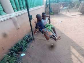 Playing on the swing at Chez Papa Geoff, Benin