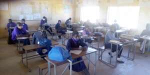 Children wearing PPE in socially distanced lesson