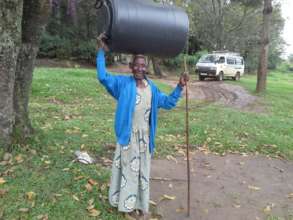 Grandmother holding a water harvesting tank