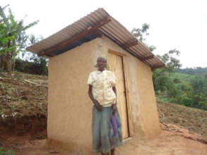 Consirantah in front of her new pit latrine