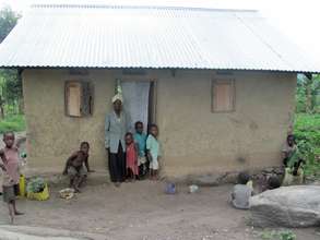 A grandmother and children next to home.