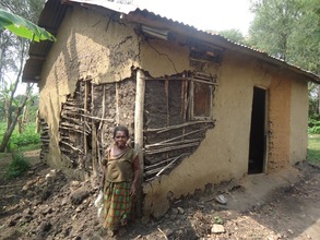 Aidah standing in front of her house