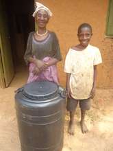 Jane & Grandchild With Their Water Harvesting Tank