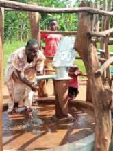 Woman at Refurbed Well, Busenya Village