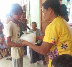 A girl receives cash and rice for her family