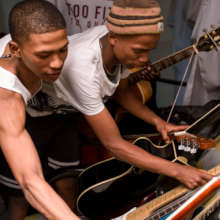 Tino and Will pick guitars