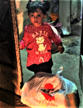 A little girl watches delivery of food supplies