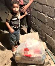 A boy watches delivery of food, hygiene supplies