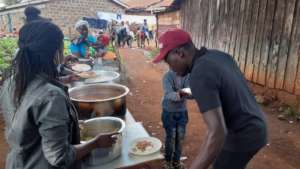Community participating in serving food to childre