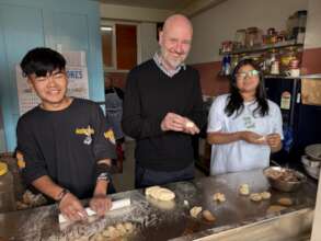 Trustee Matthew learns the art of momo-making
