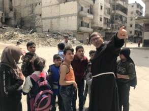 Father Firas with the children of Aleppo