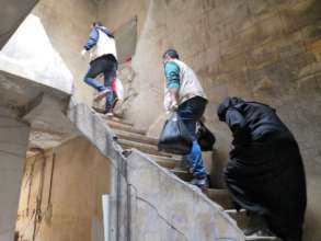 Aid distribution in damaged houses in east Aleppo