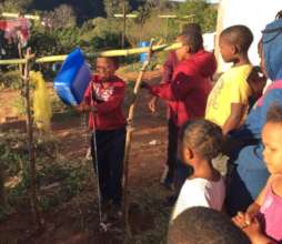 Children building a Tippy Tap water saving device