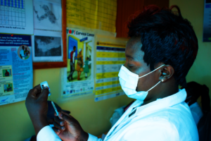 CFK staff member preparing a COVID-19 vaccine