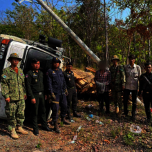 Rangers & overturned truck hauling illegal timber