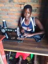 Mary at her workshop using her tailoring machine