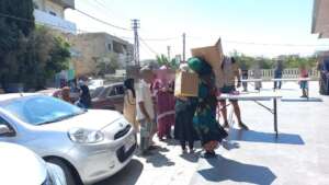 Beneficiaries carrying the boxes home