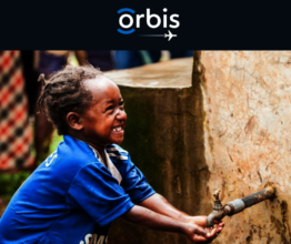 Child washing their hands at Orbis water pump.