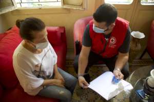 Volunteer delivering ATM card to beneficiary