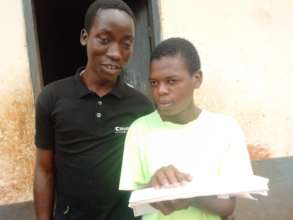 Student at Sir Appolo Kagwa reading a braille book