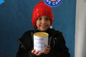 A PKU child holding medical formula