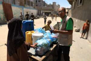 Dr. Muhammad giving food parcels to PKU families