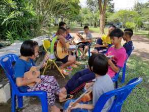 Teaching children how to play Guitar.
