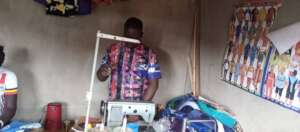 Francis standing behind an embroidery machine