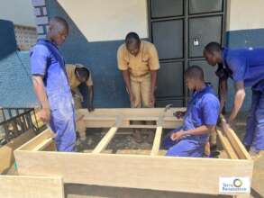 A cross section of trainees looks on a bed