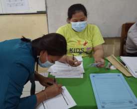 YKIP staff and a student checking the application