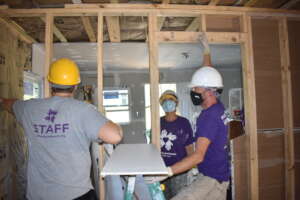 Volunteers installing drywall