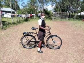 A girl receiving a bicycle to cycle to school
