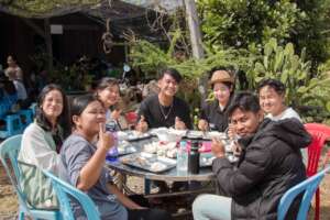 Sam, a 18 year old young man, center at table.