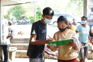 A student sign a school supplies receipt