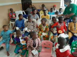 JHF team member distributing snacks to the kids