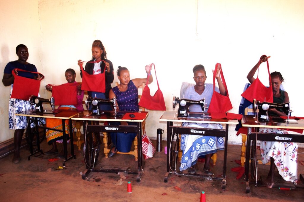 Women showcasing their first item in sewing