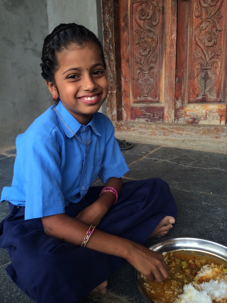 Student of bridge school enjoying her school lunch