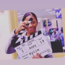 BGFS learner holding a project slate