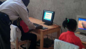 Teacher helping student in computer lab