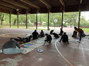 Community members painting the banner.