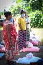 Women receive food provisions from HL staff.
