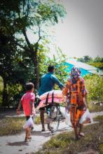 Families in southern Nepal take provisions home.