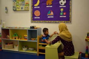 Child with teacher during preschool session