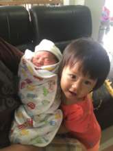 Big sister with her newborn baby brother